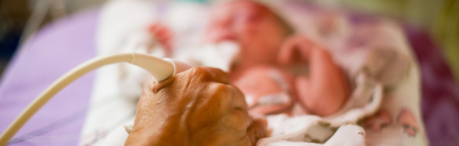 Technician performing a sonogram on a newborn