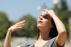 Stressed woman drying sweat with a cloth in a warm summer day